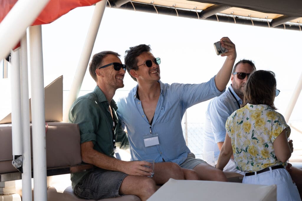 Candid shot of attendees socializing under the sailboat canopy