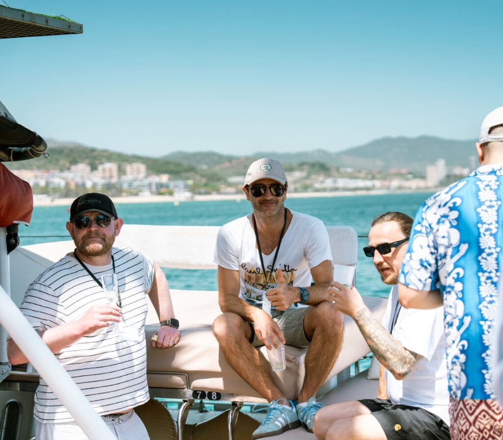 GrowBoat guests relaxing on the stern of the yacht with Barcelona in view