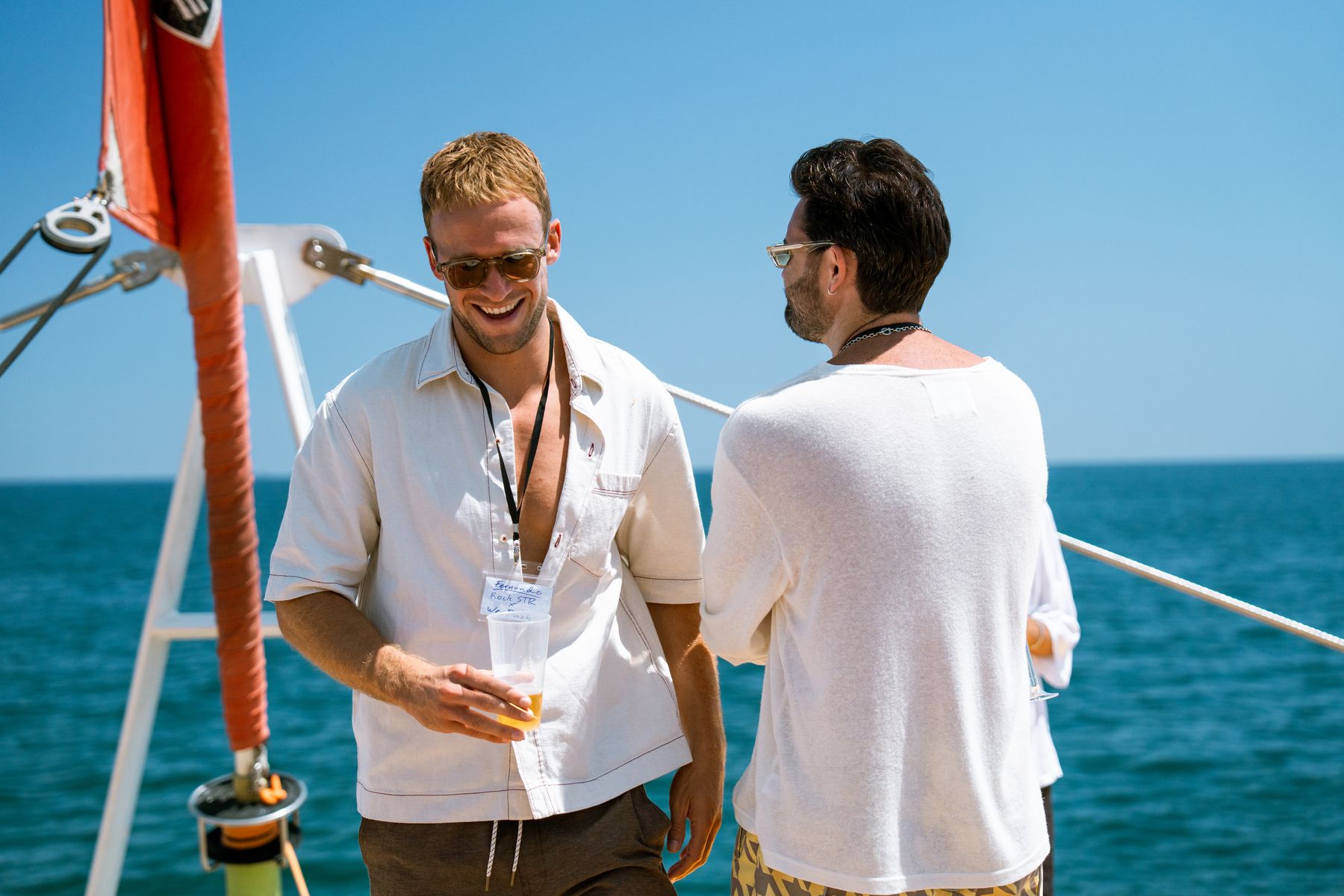 GrowBoat guests in conversation on the catamaran deck off Barcelona