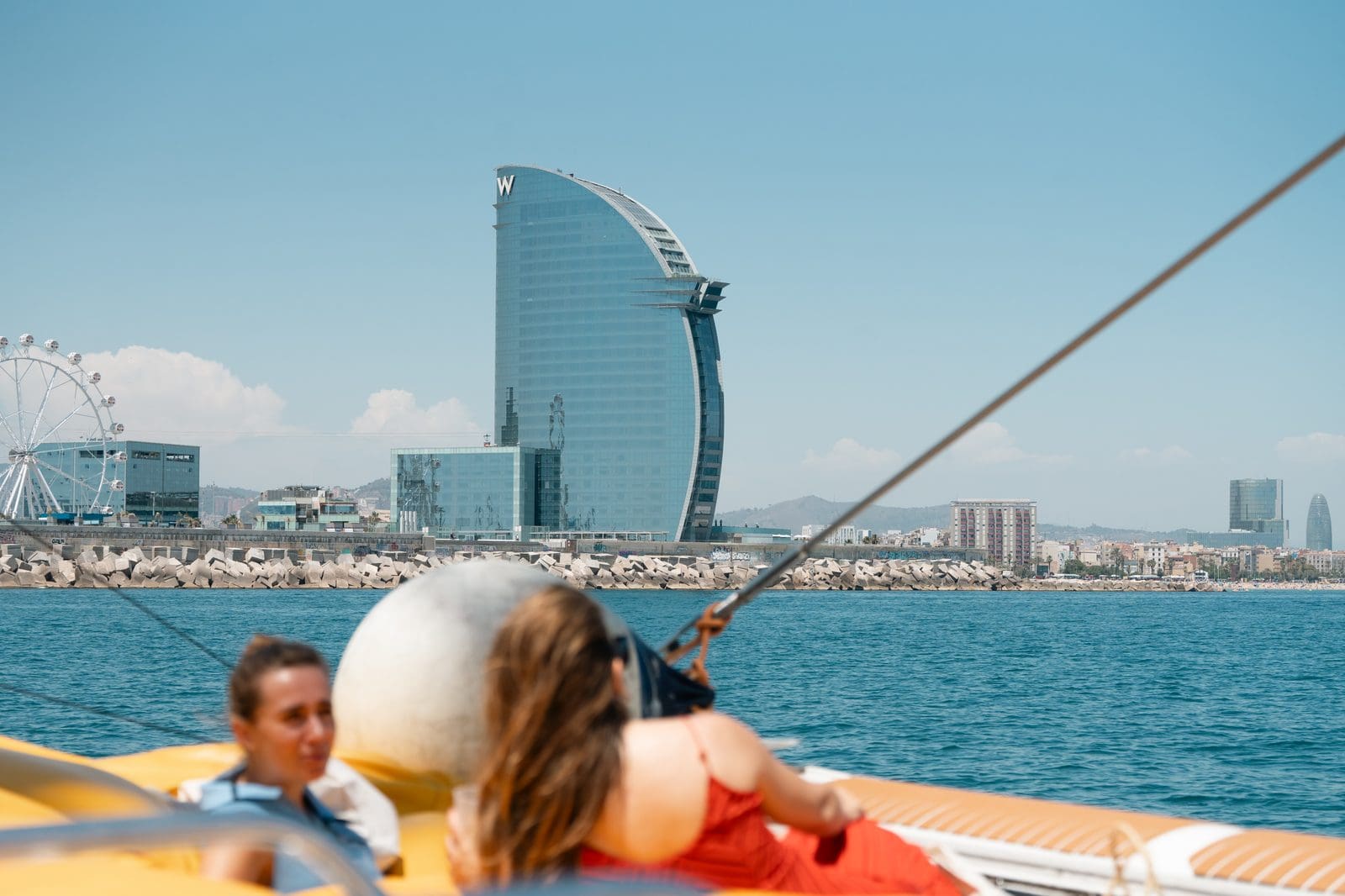 The sail-shaped W Barcelona hotel and city skyline seen from the water during GrowBoat Barcelona