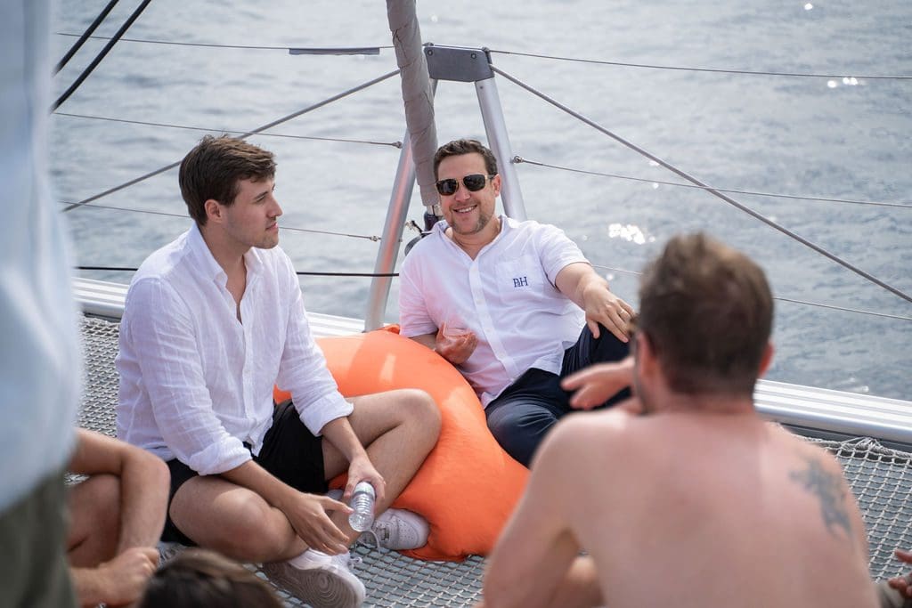 GrowBoat guests in conversation on the catamaran deck at a previous edition