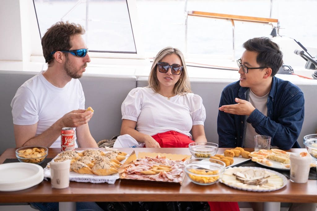 GrowBoat guests talking over food on deck in warm afternoon light at a past edition